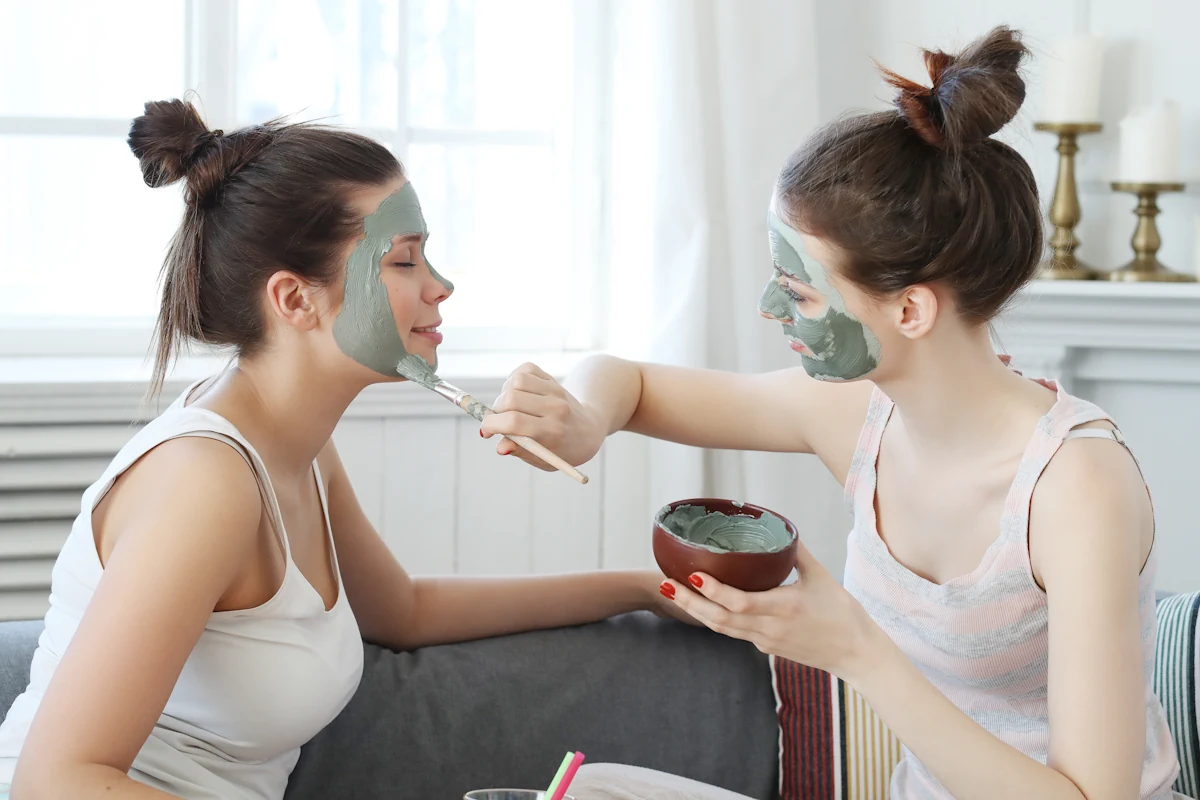 Deux femmes qui s'appliquent mutuellement un masque pour visage