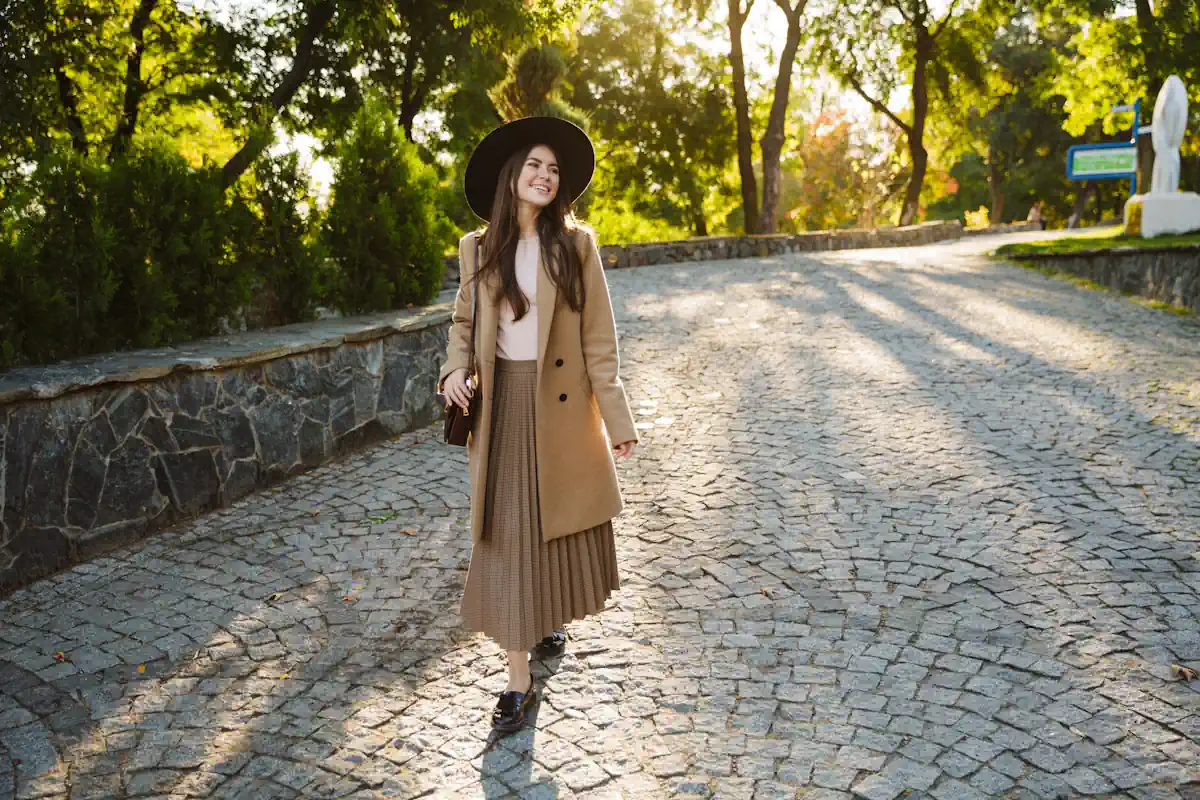 Une femme qui porte un manteau avec une jupe longue