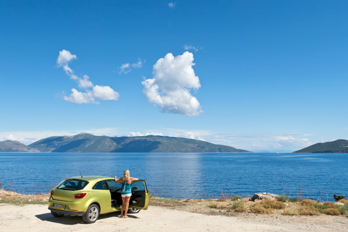 Une femme qui fait un road trip en Norvège en voiture de location
