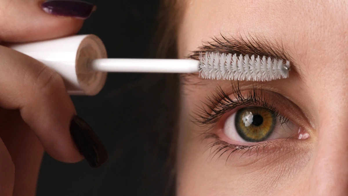 Une femme qui applique du mascara adapté aux cils courts